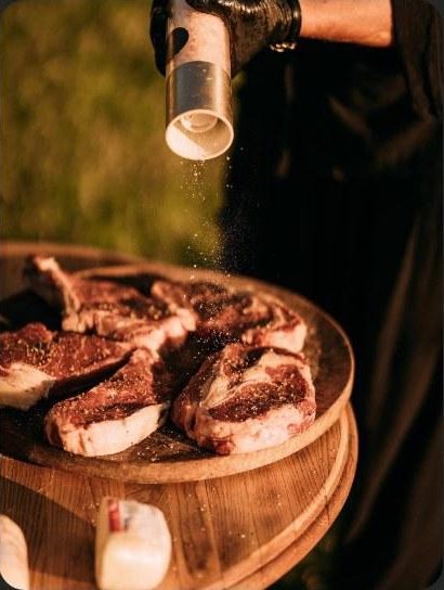 Steaks on a wooden board seasoned over the grill