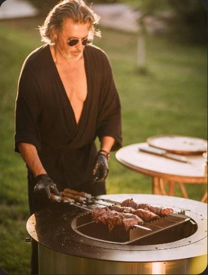 Chef preparing skewers over the fire pit